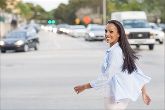 Hispanic woman crossing city street