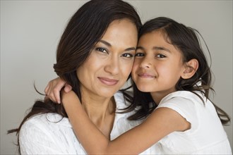 Close up of mother and daughter hugging