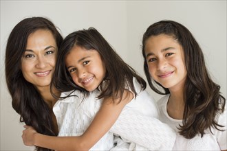 Close up of mother and daughters hugging