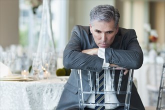 Caucasian businessman brooding in empty dining room