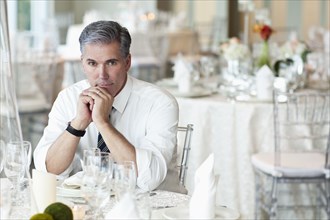 Caucasian businessman sitting in empty dining room