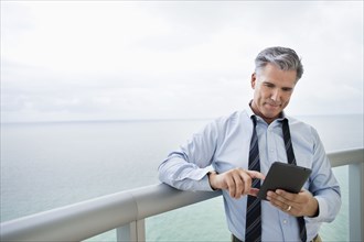 Caucasian businessman using digital tablet on balcony