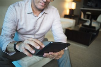 Caucasian businessman using digital tablet in hotel room