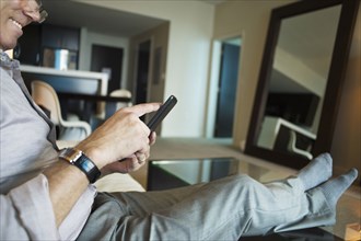 Caucasian businessman using cell phone in hotel room