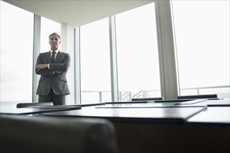 Caucasian businessman standing in empty conference room