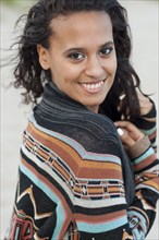 Mixed race woman wearing stylish sweater on beach