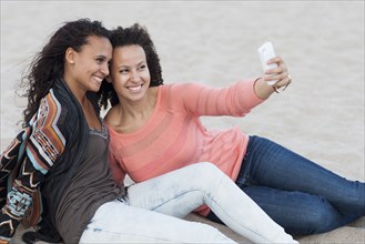Women taking selfies on beach