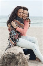 Smiling women hugging on beach