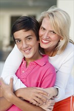 Smiling mother and son hugging outdoors