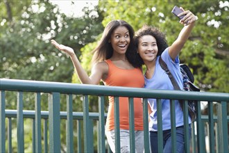 Black women taking selfie on walkway outdoors