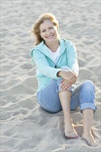 Caucasian woman sitting on beach
