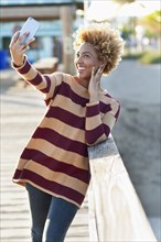 Black woman taking selfie on wooden boardwalk