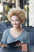 Black woman reading menu at cafe
