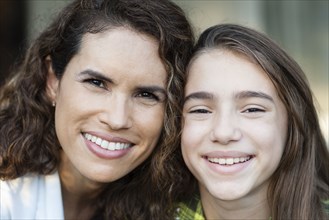 Close up of Hispanic mother and daughter smiling