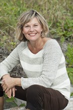 Smiling Caucasian woman sitting on beach