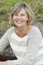 Smiling Caucasian woman sitting on beach