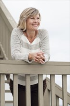 Smiling Caucasian woman standing staircase banister