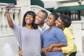 African American family taking selfie in city