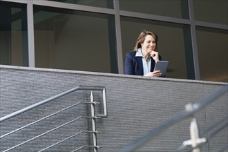 Caucasian businesswoman using digital tablet on balcony