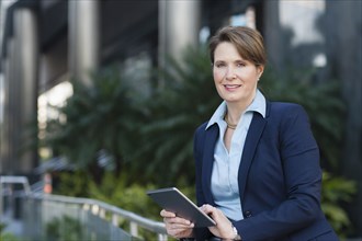 Caucasian businesswoman using digital tablet outdoors