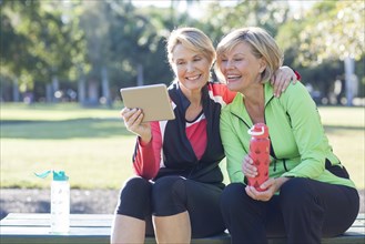 Caucasian women using digital tablet in park