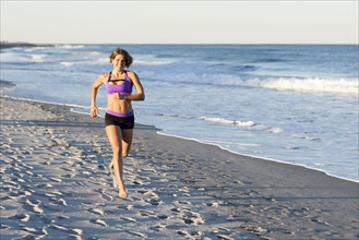 Caucasian woman jogging on beach