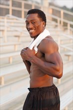 Black athlete smiling on bleachers