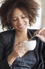 Mixed race businesswoman drinking cup of coffee