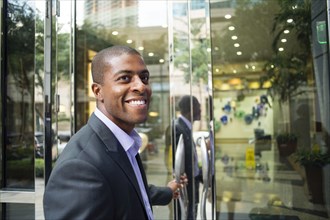 Black businessman opening office doors