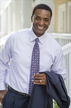 Smiling Black businessman standing outdoors