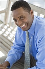 Black businessman smiling on bench
