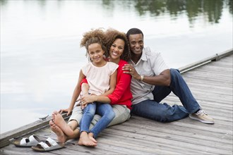 Family smiling on wooden dock
