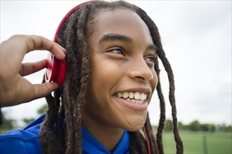 Mixed race boy listening to headphones outdoors