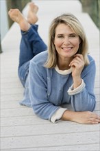 Older Caucasian woman laying on pier