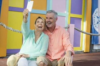 Older Caucasian couple taking selfie