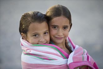 Close up Hispanic girls wrapped in towel together