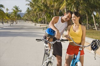 Hispanic couple on bicycles taking rest break