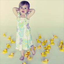Caucasian girl standing with lots of rubber ducks
