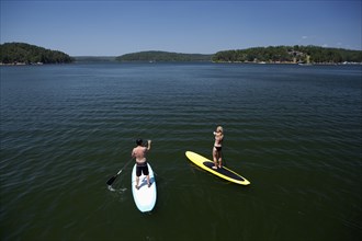 Caucasian couple on paddle boards on lake
