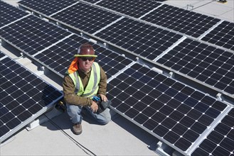 Worker sitting with solar panels outdoors