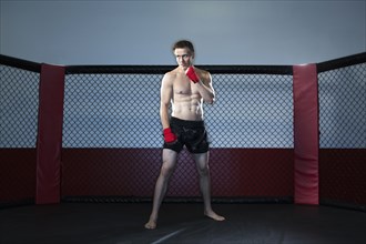 Caucasian cage fighter standing in ring