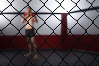Caucasian cage fighter standing in cage
