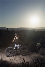Mountain biker standing in desert