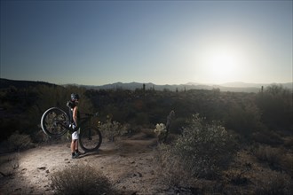 Mountain biker standing in desert