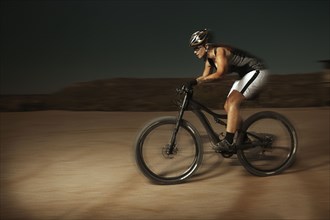 Woman riding mountain bike in desert