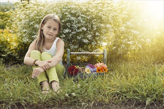 Caucasian girl sitting with basket of flowers