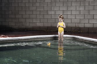 Caucasian girl standing in swimming pool
