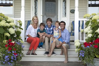 Caucasian family smiling on front porch