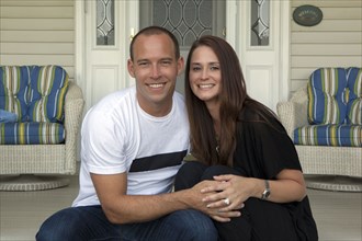 Caucasian couple smiling on front porch
