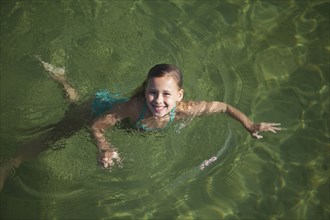 Caucasian girl swimming in lake